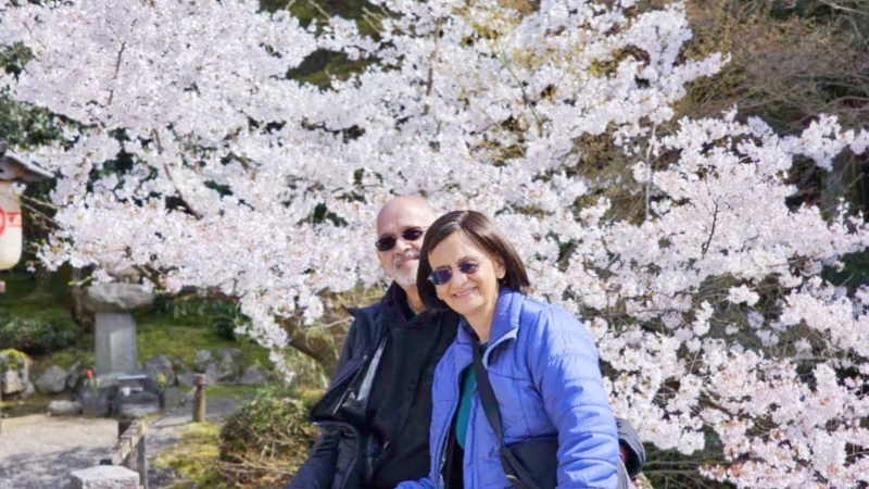 Our customers(a couple) smile under full-bloom cherry blossoms in Japan.