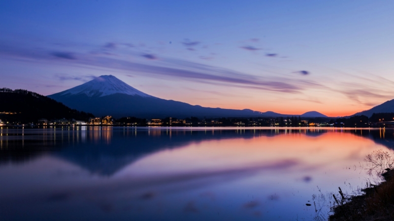 As the sun sets, Mt. Fuji and Lake Kawaguchi glow in calm evening light.