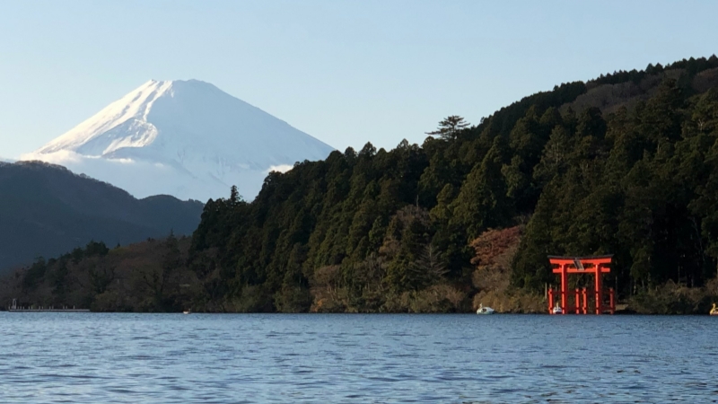 In Hakone, Mt. Fuji overlooks Lake Ashi, where the red torii of Hakone Shrine stands quietly by the water.
