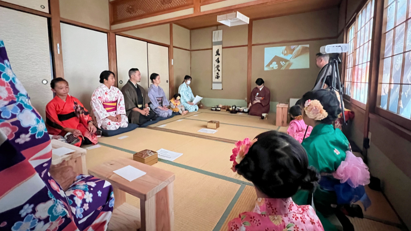 Guests dressed in traditional kimonos gather on tatami mats to experience the calming rituals of a Japanese tea ceremony.