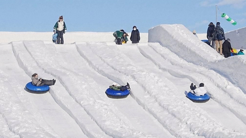 Visitors enjoy giant snow slides at the family-friendly Tsudome site of the Sapporo Snow Festival