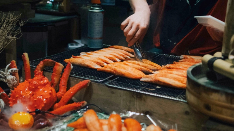 Savoring warm, charcoal-grilled seafood against the crisp Osaka winter chill.