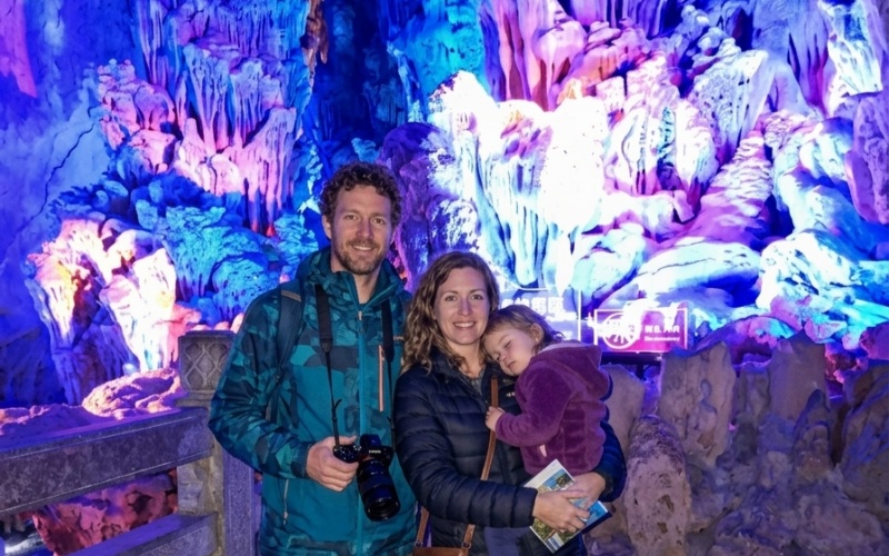 Family Exploring a Colorful Karst Cave in Guilin, China