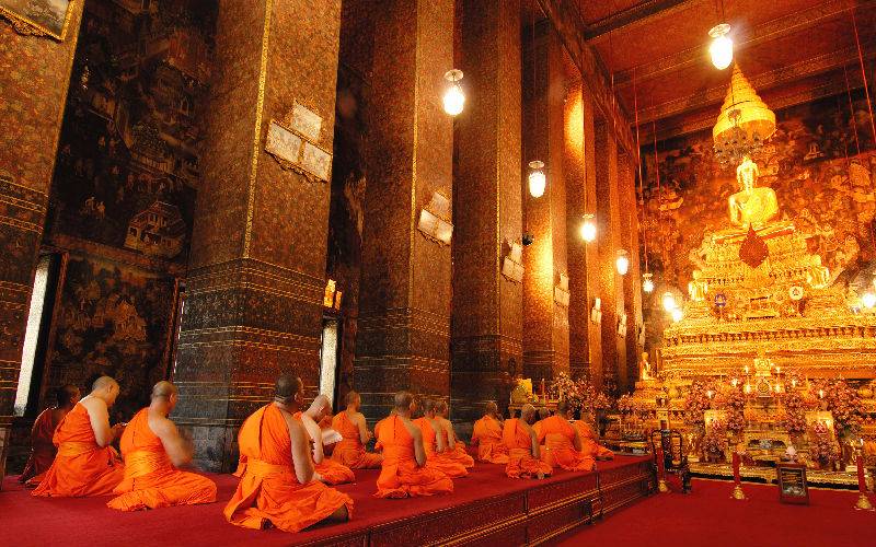 Picture: Beautiful golden buddha statue and monks in Wat Pho Temple.